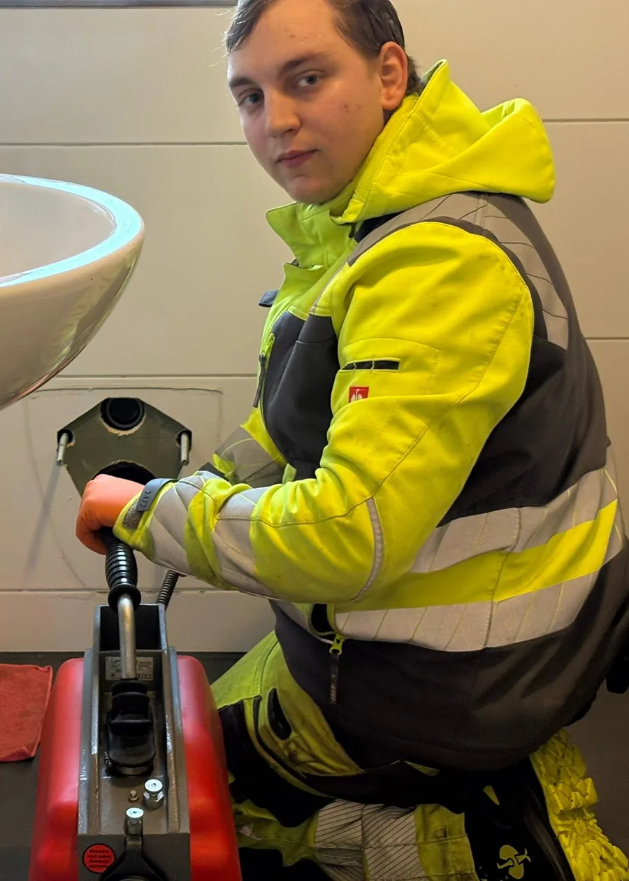 Inhaber von HRR Rohrreinigung mit der Rohrreinigungsmaschine am Waschbecken