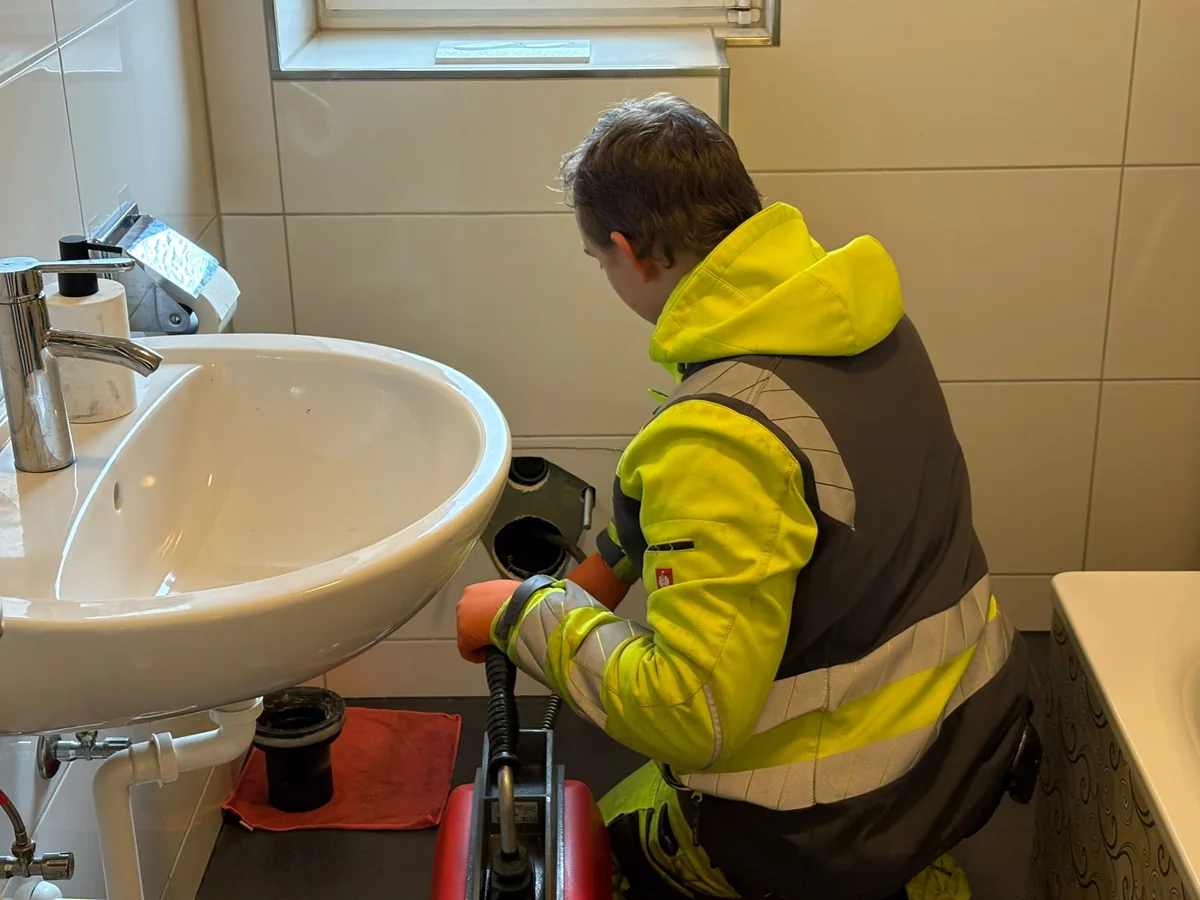 Mitarbeiter von HRR Rohrreinigung arbeitet an einer Abflussleitung im Gebaeude