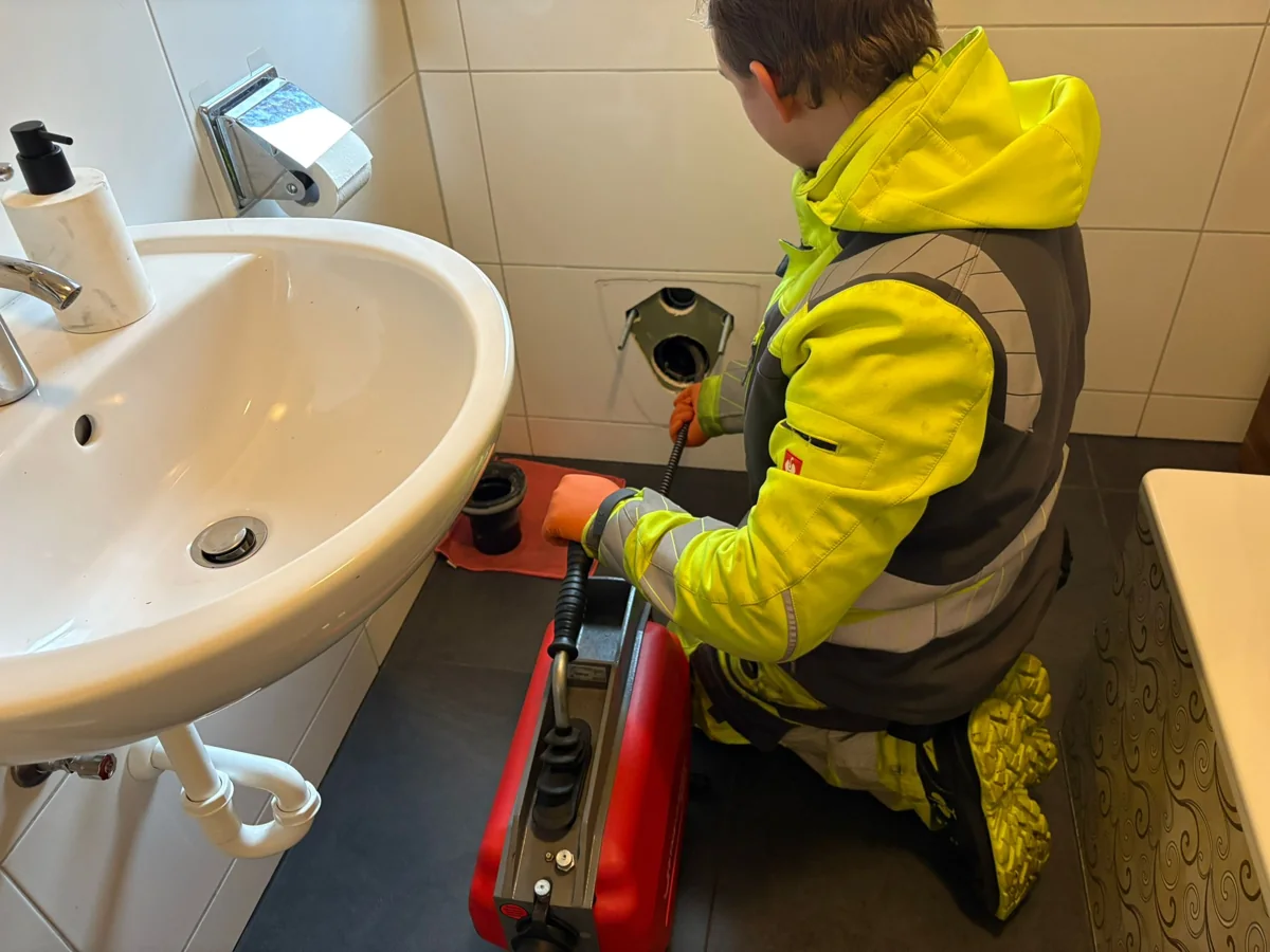 Mitarbeiter von HRR Rohrreinigung arbeitet mit der Reinigungsspirale am Abfluss