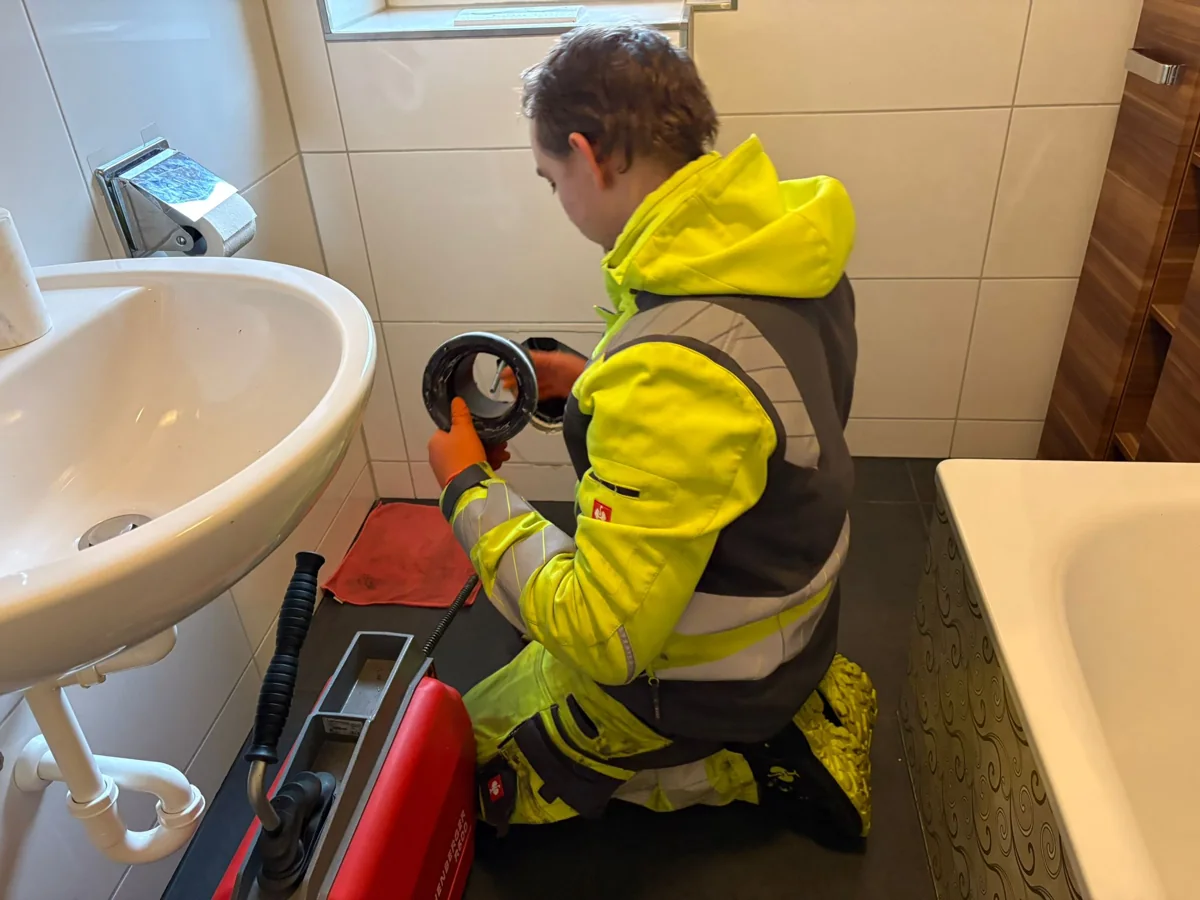Mitarbeiter von HRR Rohrreinigung bei der Abflussreinigung im Badezimmer